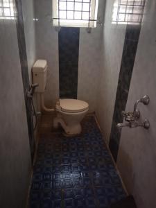 a bathroom with a toilet and a blue tile floor at KINGS TOWN - Cyra Bliss County in Coimbatore +90 photos