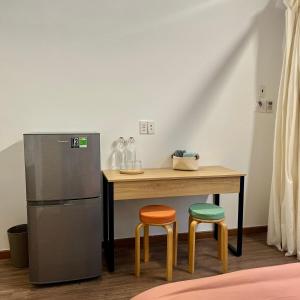 kuchnia ze stołem z 2 stołkami i lodówką w obiekcie Anh's House w Ho Chi Minh