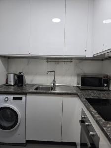 a kitchen with a sink and a washing machine at Casa Acogedora in Hospitalet de Llobregat