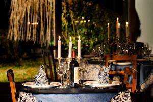 een tafel met een fles wijn en kaarsen erop bij La Vignola Country Hotel in Ceprano