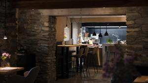 a kitchen with a counter and a bar with stools at Boutique Hotel Casa Giovanoli in Tomils