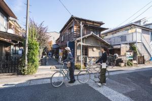 two people are standing with their bikes in the street at hanare in Tokyo