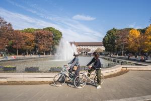 two people on bikes in front of a fountain at hanare in Tokyo
