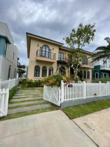 ein weißer Gartenzaun vor einem Haus in der Unterkunft 3BR Villa Novaworld Phan Thiet in Bình Tú