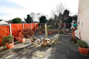 a garden with three dogs sitting on a patio at The Northwood in Colwyn Bay