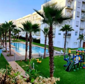 un resort con parco giochi e palme di Apparemment de luxe vue piscine a Bouznika