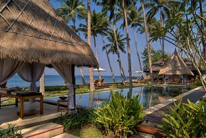 a resort with a swimming pool and palm trees at The Chandi Boutique Resort & Spa in Senggigi