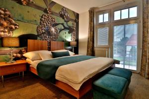a bedroom with a large bed and a large window at Boutique Hotel Golf Garni in Mikulov