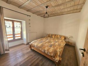a bedroom with a bed and a wooden floor at Maison au cœur du Jura in Saint-Laurent-en-Grandvaux