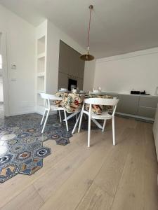 una sala da pranzo con tavolo e sedie su un tappeto di Isabel Apartment ad Ancona Altre 7 foto