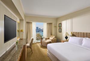 una camera d'albergo con un letto e una televisione di Hilton Cairo Grand Nile a Il Cairo