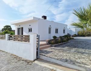 a white house with a fence in front of it at Marisa in Ierapetra