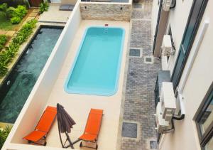 an overhead view of a swimming pool with orange chairs at Stunning modern luxury 3-Bedroom Apart with pool flic en flac in Flic-en-Flac