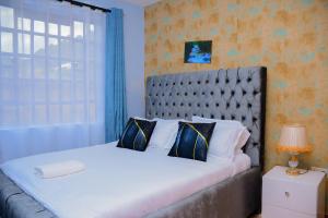 KisiiMKHomes的一间带大床和大窗户的卧室