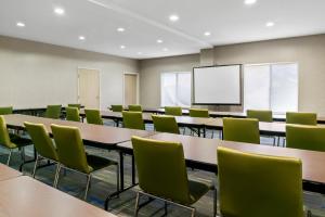 an empty classroom with tables and chairs and a screen at Holiday Inn Express Hotel & Suites Marion by IHG in Marion +44 photos