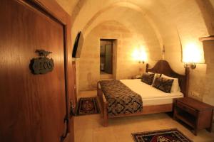 1 dormitorio con 1 cama en una habitación pequeña en Georgios Cave Cappadocia, en Ürgüp