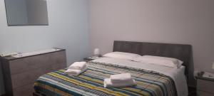 a bedroom with a bed with two towels on it at Harmony in Torre Archirafi