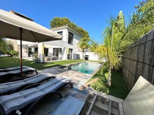 une cour arrière avec une piscine et une maison dans l'établissement Villa récente Sanary,piscine, 3 chambres ,proche mer et centre-ville, à Sanary-sur-Mer