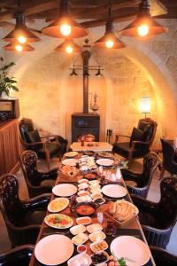 Una mesa larga con platos de comida encima. en Georgios Cave Cappadocia, en Ürgüp