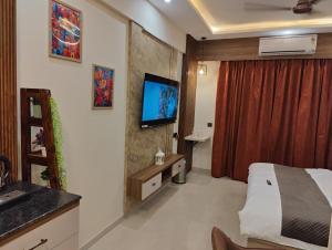 a hotel room with a bed and a tv on a wall at Nestle Luxury Homes 1 in Lucknow