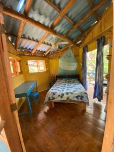 ein Schlafzimmer mit einem Bett und einem Tisch in einem Zimmer in der Unterkunft Casa de bambu e garrafas no litoral de Serra Grande in Uruçuca