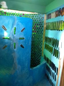 ein Zimmer mit einer blauen Wand mit einer Uhr drauf in der Unterkunft Casa de bambu e garrafas no litoral de Serra Grande in Uruçuca