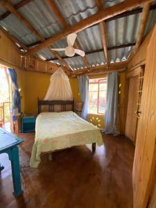 ein Schlafzimmer mit einem Bett und einer Decke in der Unterkunft Casa de bambu e garrafas no litoral de Serra Grande in Uruçuca