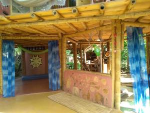 ein Holzspielhaus mit einer Bühne und Vorhängen in der Unterkunft Casa de bambu e garrafas no litoral de Serra Grande in Uruçuca + 8 Fotos