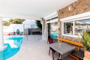 una villa con piscina e tavolo di Sunrise Studio Puerto Rico a Mogán