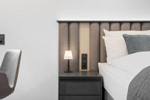 a bed with a side table with a lamp on it at 1-2 Personen - Parkplatz - Fahrradgarage - Zentrum - Küche - Klima in Sankt Martin