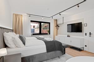 a white bedroom with a large bed and a tv at 1-2 Personen - Parkplatz - Fahrradgarage - Zentrum - Küche - Klima in Sankt Martin