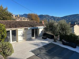 a house with a patio with trees in the yard at L'olivier in Gattières