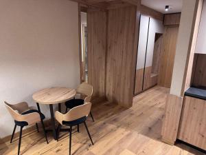 a dining room with a wooden table and chairs at Apartman C234 Aparthotel Vučko Jahorina privatni apartman in Jahorina