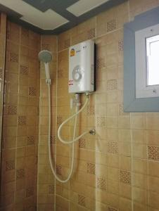 a shower with a shower head in a bathroom at ที่พักใกล้วัดพระธาตุหมื่นหิน-บ้านโฮมฮัก HomeHug in Ban Kaeng Nang