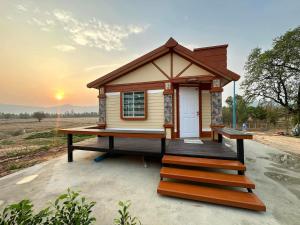a tiny house on a platform with the sunset in the background at ที่พักใกล้วัดพระธาตุหมื่นหิน-บ้านโฮมฮัก HomeHug in Ban Kaeng Nang