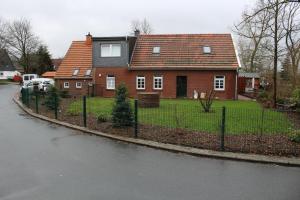 uma casa com uma cerca em frente a uma rua em Haus Oltmanns em Quanens