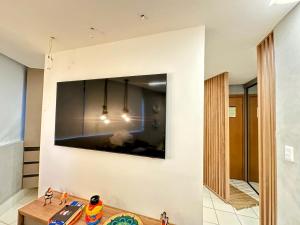 a living room with a tv on the wall at Muro Alto Marulhos flat cinematográfico in Porto De Galinhas