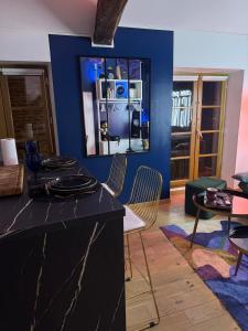 a living room with a black counter and a blue wall at Aux Petits Oignons in Albi
