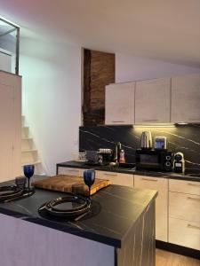 a kitchen with a counter with two wine glasses on it at Aux Petits Oignons in Albi +3 photos