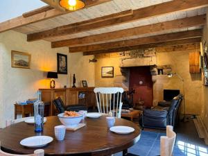 a dining room with a wooden table and a living room at Rhun Even, charmante maison bretonne pour 6 personnes in Plougasnou