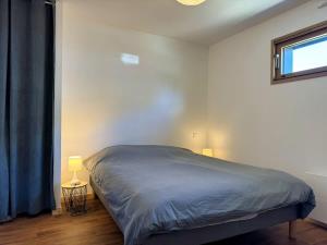 a bed in a bedroom with a window and a bedskirtspectspectspectspects at Rhun Even, charmante maison bretonne pour 6 personnes in Plougasnou