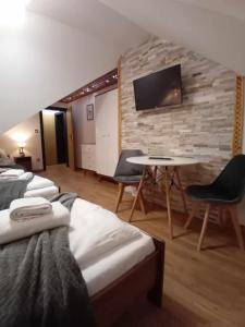 a room with three beds and a table and a tv at Apartament Góralski Duet 8-osobowy - apartament na wyłączność in Bukowina Tatrzańska