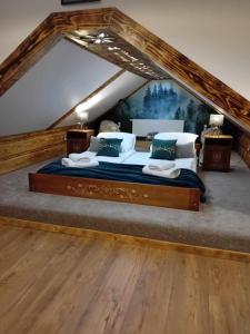 a bedroom with a large bed in a attic at Apartament Góralski Duet 8-osobowy - apartament na wyłączność in Bukowina Tatrzańska