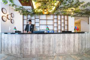 a man in a suit sitting at a bar at Tengealti Resort Quba in Quba +30 photos