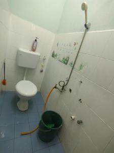 a bathroom with a toilet and a bucket at Dinaz Homestay Taman Limbungan Permai Melaka in Melaka