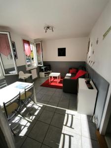 ein Wohnzimmer mit Couch und Tisch in der Unterkunft La Petite Maison in Murat-le-Quaire