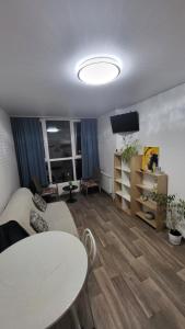 ein Wohnzimmer mit einer Couch, einem Tisch und einem Fernseher in der Unterkunft New clean apartments in Winnyzja