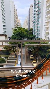 a hammock in the middle of a city with buildings at Relax Pitangueiras Guarujá in Guarujá