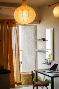 プネにあるRoom Dawn 12th floor Pvt studio w Balcony & Wifiのデスク、窓、ランプが備わる客室です。