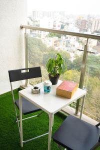 プネにあるRoom Dawn 12th floor Pvt studio w Balcony & Wifiの白いテーブルと椅子